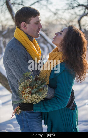 Elegant young couple in winter Apple Orchard, a love story.Christmas Stock Photo