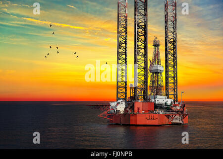 Oil drilling rig in sunset time. Stock Photo