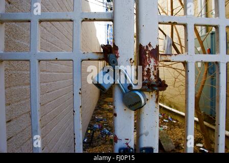 Two locks on rusty chain on fence in uptown charlotte Stock Photo