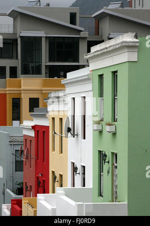 Brightly colored houses in the Bo-Kaap area of Cape Town slope down a street at the foot of Signal Mountain. Stock Photo
