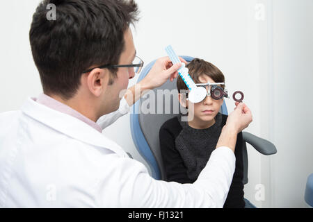 Optometrist examining eyesight of boy Stock Photo