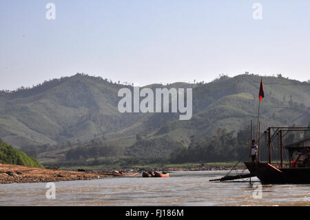 Traditional boat, Mekong river and mountains, Laos Stock Photo