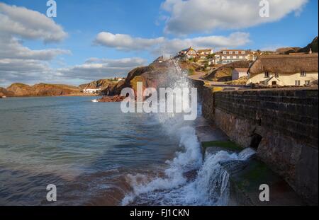 Waves crashing against the sea wall at Hope Cove, Devon, England Stock Photo
