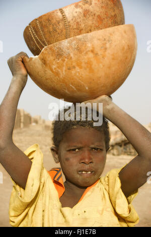 Portrait of Africain child carrying a calabash in Djenné , Mali Stock Photo