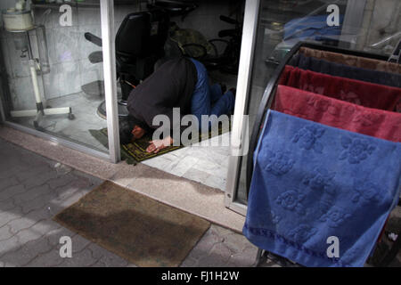 Man doing Friday prayer in his hairdresser shop in Amman, Jordan Stock Photo
