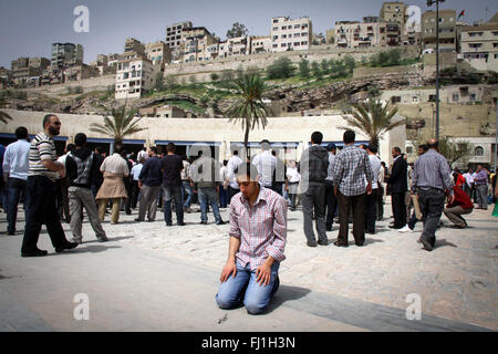 Man prays in the streets during protestations in the streets of Amman, Jordan Stock Photo