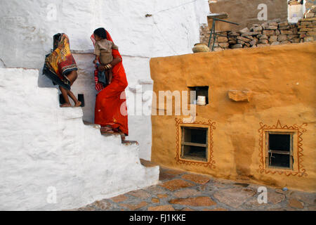 Woman climbing stairs of a traditional house in the fort of jaisalmer,  India Stock Photo