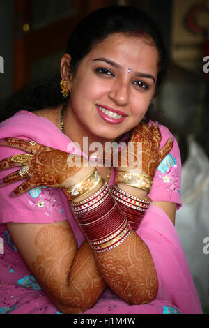 Beautiful smiling Indian woman with henna , saree and bangles in Delhi Stock Photo
