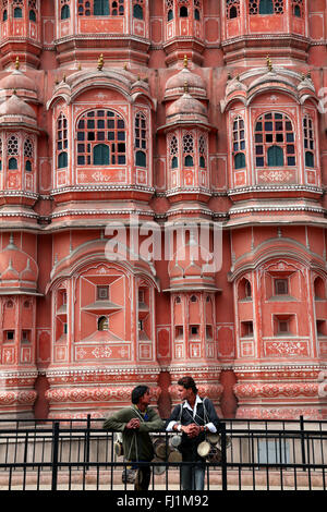 Two men are talking in front of Hawa Mahal – "Palace of Winds" Jaipur, India Stock Photo