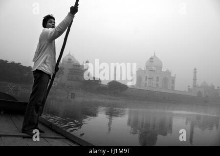 Man on boat on Yamuna river, with Taj Mahal, in the early morning, Agra India Stock Photo