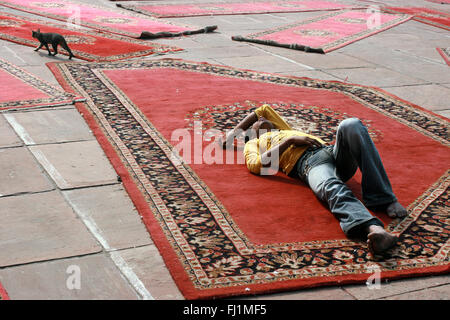 Muslim man sleeping on carpet at jama Masjid (great mosque) of Old Delhi , India Stock Photo