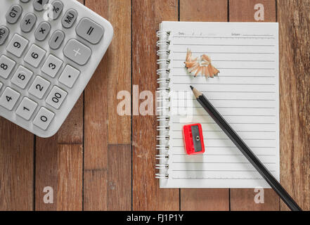 Paper note with pencil and calculator on wooden background Stock Photo