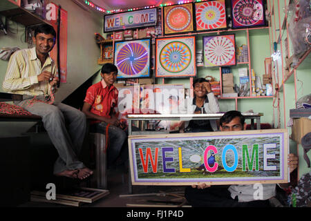 Indian guys are pmosing in a shop with "WELCOME" board  in Bhuj, Gujarat Stock Photo