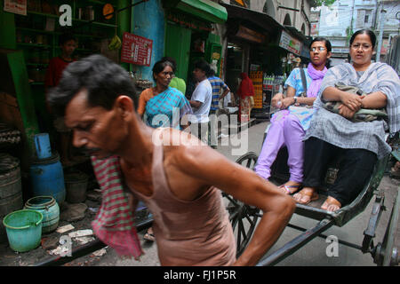 Rickshaw driver carrying passengers near New market, Kolkata Stock Photo