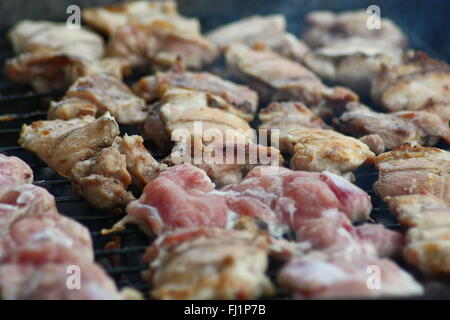Barbecuing meat on charcoal fire closeup image. Stock Photo