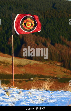 Manchester United flag in snow on Pen Pych hill above Rhondda Fawr valley, Mid Glamorgan, Wales, United Kingdom
