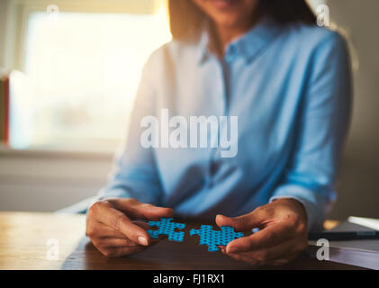 Business woman connecting puzzles, closeup of hands, success concept Stock Photo