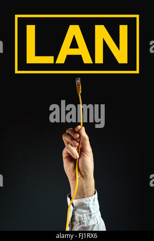 Businessman plugging LAN cable to connect to local area network, business solution. Stock Photo