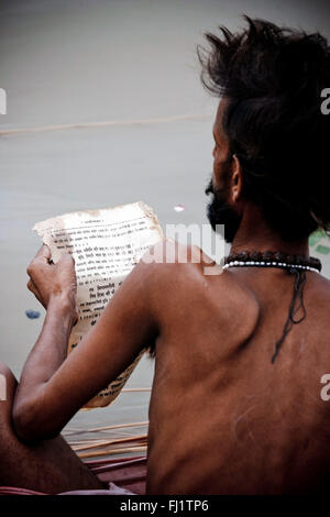 Sadhu reading sanskrit book in Varanasi, India Stock Photo