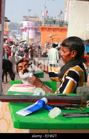 Street barber on a ghat of Varanasi, India Stock Photo