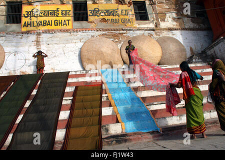 Women make their sarees dry on the banks of the ganges on the ghats of Varanasi, India Stock Photo