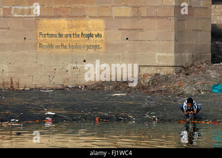 Man drinking holy water in polluted Ganges river in Varanasi , India Stock Photo