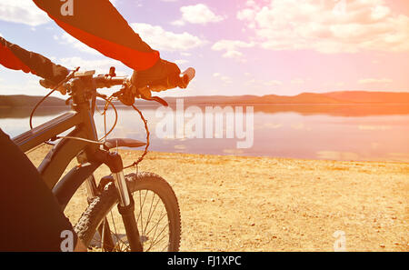 man with bike on a mountain lake Stock Photo