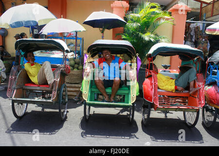 Becak drivers in a street of Yogyakarta , Indonesia Stock Photo