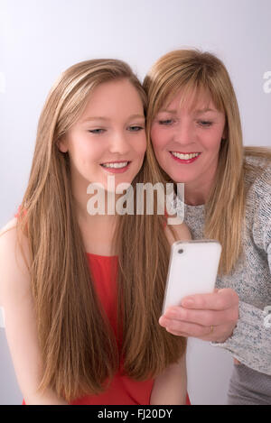 Expressive portrait of mother and daughter using a mobile phone Stock Photo