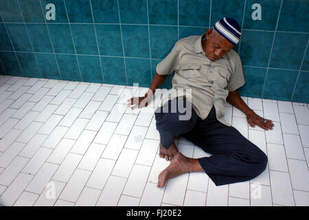 Muslim man sleeping in a mosque in Jakarta, Indonesia, during Ramadan Stock Photo
