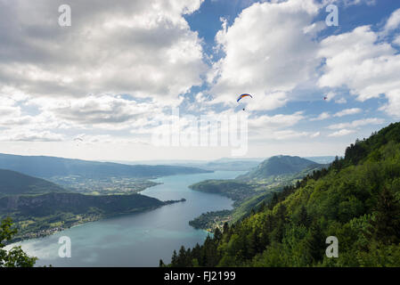 View from the mountain pass Col de la Forclaz on paragliders over the lake Lac d'Annecy, Savoy, France on a sunny spring day Stock Photo