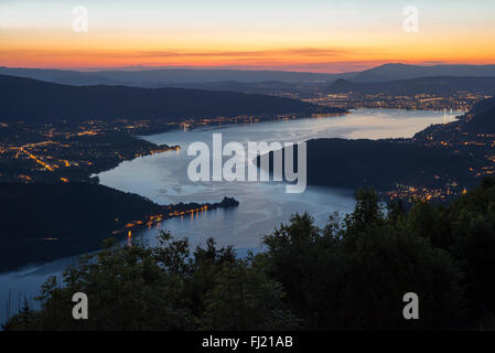 View from Forclaz mountain pass on the Lac d'Annecy at dusk with illuminated streets and urban settlements, Savoy, France Stock Photo
