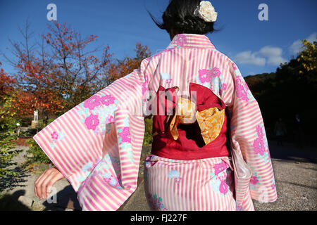 A Japanese woman with traditional kimono woman is walking in Maruyama Park in Kyoto Stock Photo