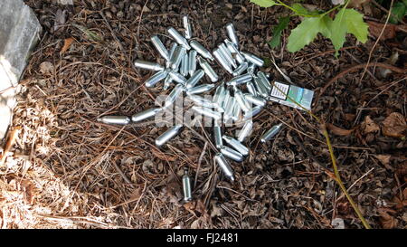 Dumped pile of empty silver canisters of nitrous oxide, or laughing gas, used as legal high picutred in London Stock Photo