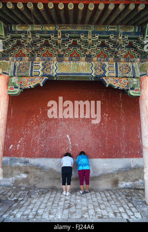 Two women praying inside the Inside the Erdene Zuu monastery , Mongolia Stock Photo