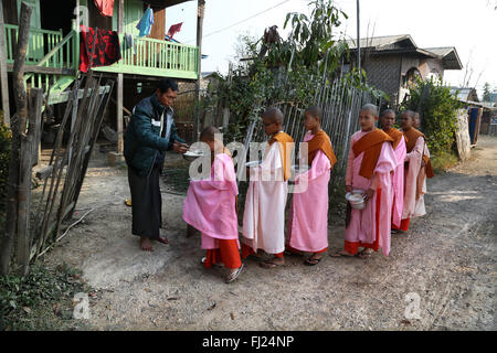 Buddhist nuns going for alm tak bat/ takbat  in the early morning near Inle lake, Myanmar Stock Photo