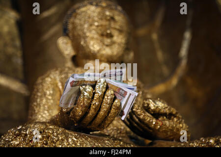 Buddha statue with bank notes in his hand, Old Bagan, Myanmar Stock Photo