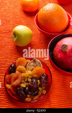 dried and fresh fruits on the textile orange background Stock Photo