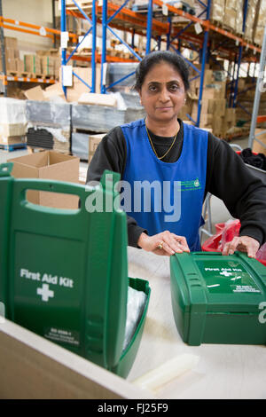 Woman packing First Aid Kit Boxes in a Warehouse in Hendon, England Stock Photo