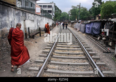 Buddhist monks walk along the train tracks in Kandy, Sri Lanka Stock Photo