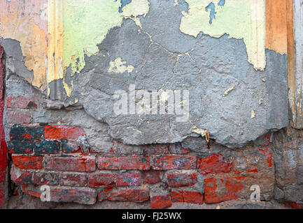 Grungy wall half covered with old plaster Stock Photo