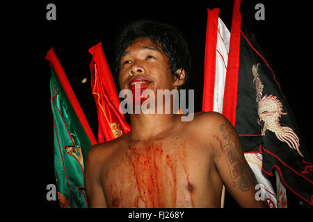 Bleeding people and procession with during traditional annual vegetarian festival in Krabi, Thailand Stock Photo