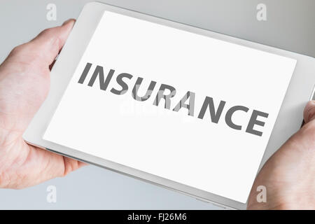 Insurance text displayed on touchscreen of modern tablet or smart device. Concept of fin-tech company. Stock Photo