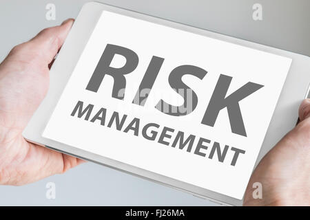 Digital risk Management texted displayed on touchscreen of modern tablet or smart device. Stock Photo