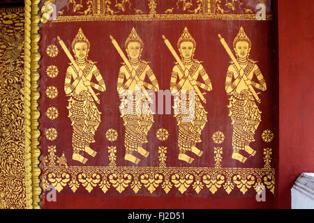 Four Buddhist deities are stenciled on the wall of Wat Si Bun Heuang in the former French Provincial town of LUANG PROBANG - LAO Stock Photo