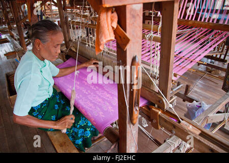 The weaving of LOTUS SILK fabric from the stalks of the lotus plant is a local industry of INLE LAKE - MYANMAR Stock Photo