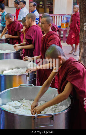 BUDDHIST MONKS are fed each day at 11 AM at the MAHAGANDAYON MONASTERY - MANDALAY, MYANMAR Stock Photo