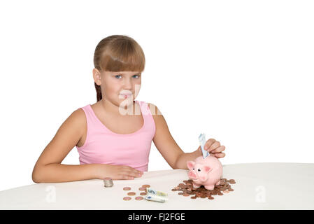 Girl putting money in  piggy bank on the table isolated Stock Photo