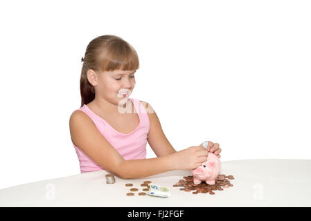 Girl putting money in piggy bank on the table isolated Stock Photo