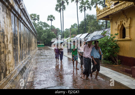 BAGAN, Myanmar - Visitors brave a downpour at the Myazedi (or Mya Zedi) Pagoda, in the northern part of Myinkaba Village, just woth of Old Bagan. Myazedi translates as 'emerald stupa.'